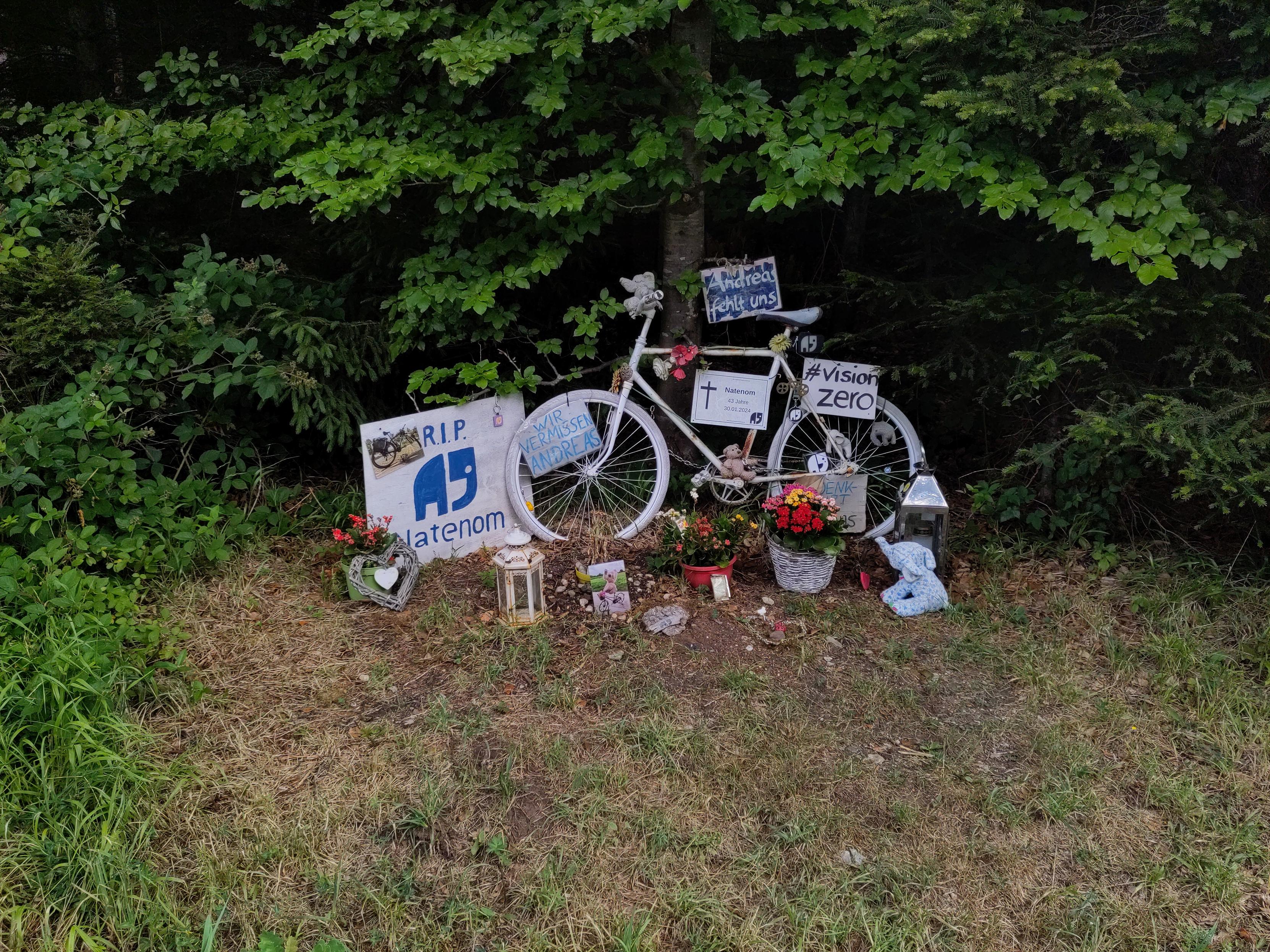 Natenoms Gedenkstelle mit Ghostbike, Plakaten, Blumen, Stofftieren.